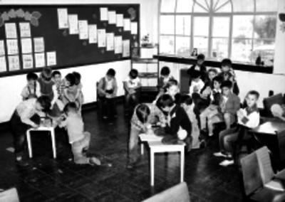 Alumnos realizando trabajos manuales en un salón