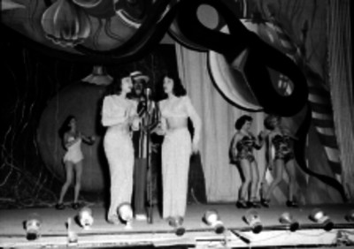 Cantantes acompañados por bailarines en escena