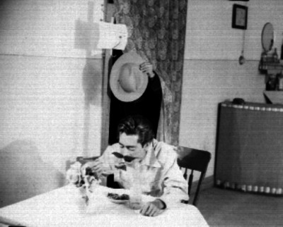 Hombre comiendo mientras le roban su sombrero