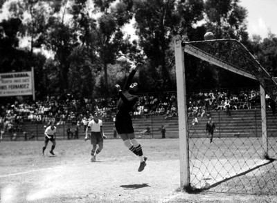 Portero desvía un tiro de gol con el puño hacia arriba de la portería