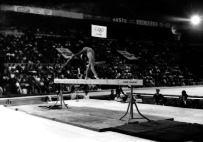 Gimnasta dá media vuelta para atrás en la viga de equilibrio