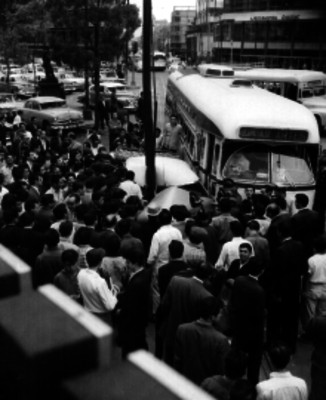 Aglomeración observando un automóvil y autobus impactados en una avenida de la Cd. de México
