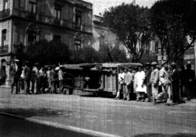 Gente junto a un camión volcado en una calle