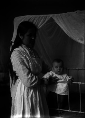 Mujer deteniendo a un niño en su cuna