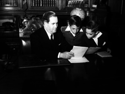 Manuel Ávila Camacho muestra libro a niños, en oficina de Palacio Nacional