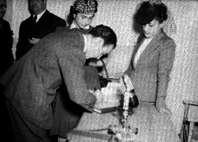 Parejas haciendo anotaciones en un documento en la oficina de la Radiodifusora X.E.W.