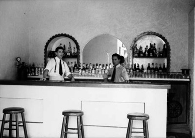 Cantineros atienden la barra de un bar