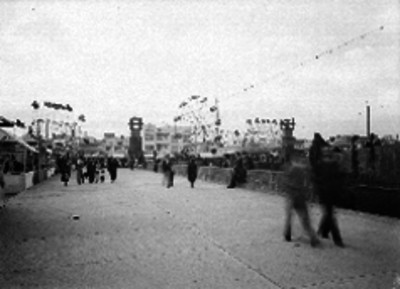 Gente caminando por la feria instalada en la plaza del Monumento de la Revolución, "Diversiones Cárdenas"