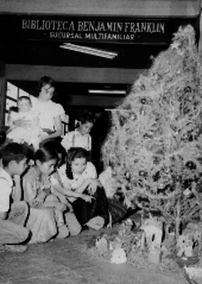 Niños decorando el nacimiento y el árbol de navidad en la biblioteca Benjamín Franklin