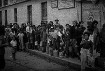 Gente de clase media y baja formados con garafas para comprar petróleo, retrato