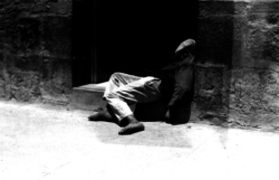 Hombre borracho durmiendo en el escalón de una casa