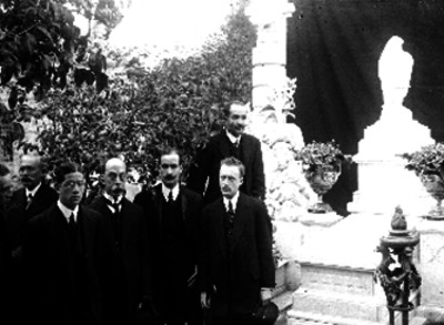 Hombres reunidos en el panteón junto a unas tumbas