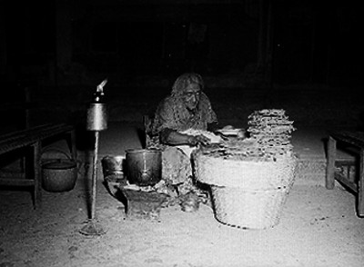 Mujer vende buñuelos en la banqueta de una calle