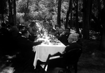 Hombres elegantes durante un banquete en un jardín
