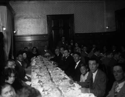 Hombres y mujeres vestidos elegante disfrutando de un banquete en un salón