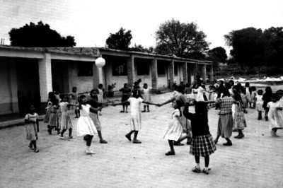 Niñas juegan en los patios de la escuela rural