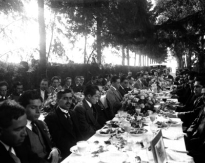Hombres disfrutando de un banquete en un parque