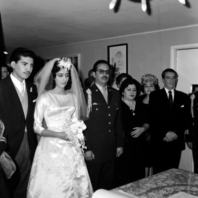Novios celebran su matrimonio civil, acompañados de sus padres y familiares en una habitación