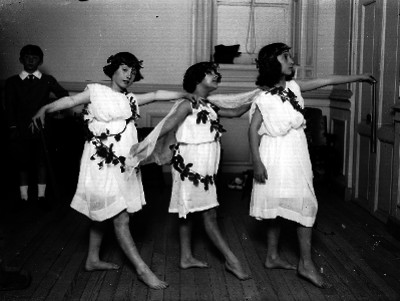 Estudiantes interpretando una danza con trajes típicos de la antigua Grecia
