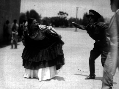 Estudiantes con vestimenta indígena y uniforme judicial, bailando en la calle