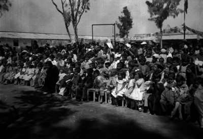 Alumnos y maestros presenciando una ceremonia escolar en el patio de una escuela