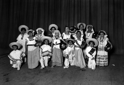 NIños y niñas vestidos con trajes regionales en un foro, retrato