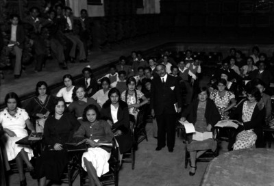 Profesor en compañía de alumnos, en una salón de clases