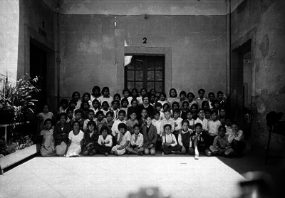 Estudiantes con su maestra en el patio de una escuela, retrato de grupos
