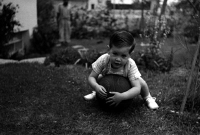 Hijo de Gaona abrazando un balón de basquetboll en un jardín, retrato