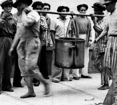 Internos caragando la olla de la comida