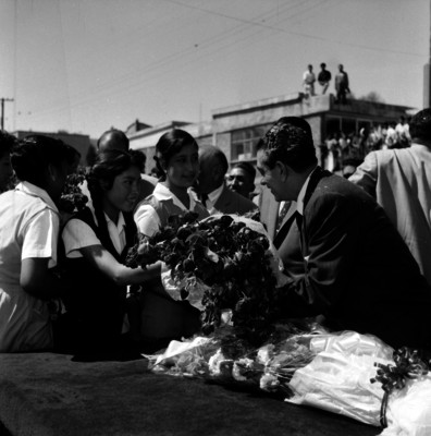 López Mateos recibiendo flores de una mujer durante su recorrido
