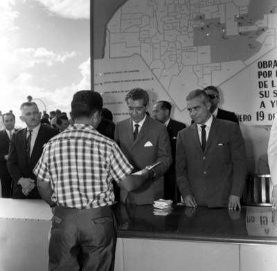 Adolfo López Mateos y miembros de su comitiva, haciendo entrega de títulos de propiedad a habitantes Yucatecos, durante una ceremonia