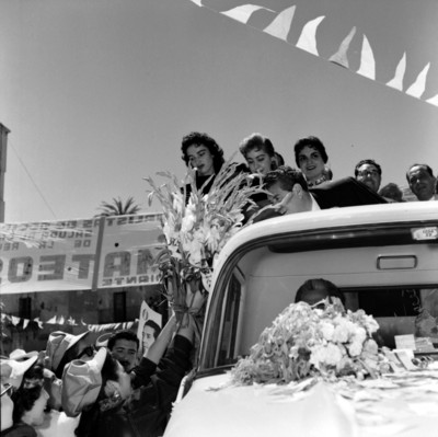 Adolfo López Mateos en un camión recibiendo flores de una partidaria, durante su campaña electoral en Guadalajara