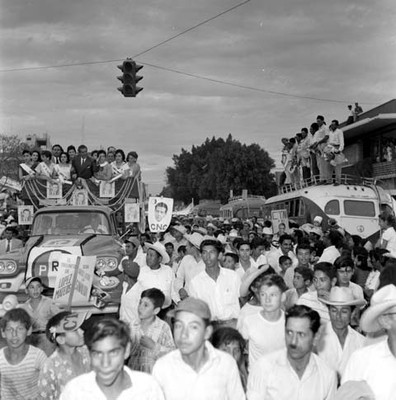 Adolfo López Mateos y edecanes en un camión, haciendo un recorrido durante su campaña electoral