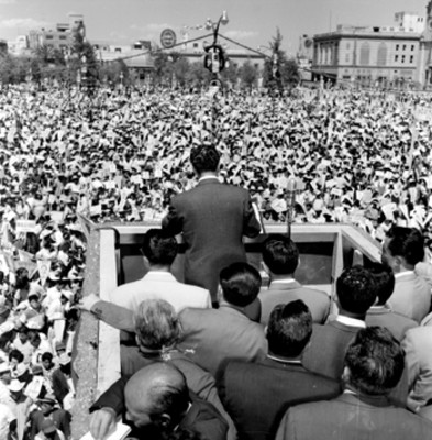 Adolfo López Mateos acompañado de políticos, observando un mitin durante su gira electoral por Monterrey