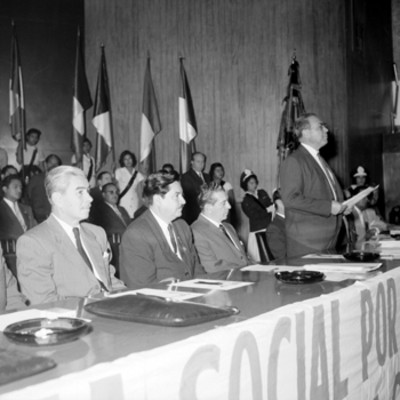 Adolfo López Mateos y funcionarios públicos, escuchando la lectura de un documento, durante la inauguración del Congreso de Caminos