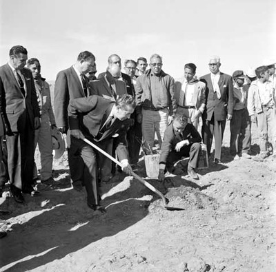 Adolfo López Mateos colocando la primera piedra de una construcción; acompañado por funcionarios y trabajadores