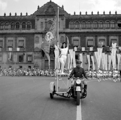 Motociclista con una mujer en el desfile del 20 de Nov. en el zócalo del D.F.