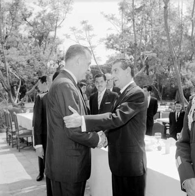 Adolfo López Mateos felicitado por un funcionario durante su cumpleaños en el jardín de Los Pinos