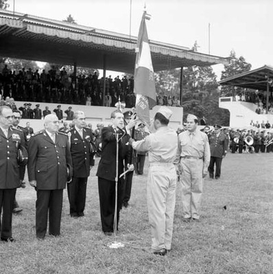 Adolfo López Mateos entregando la bandera a un soldado durante la ceremonia de reposición de bandera al Sindicato de trabajadores de la Industria Militar