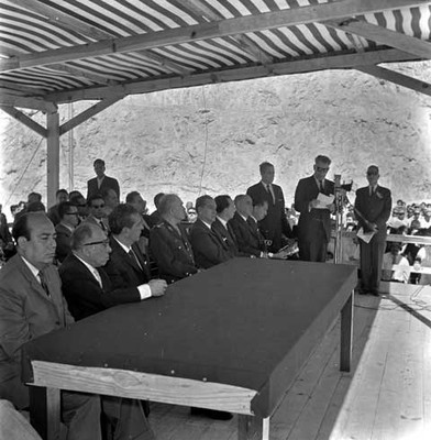 Adolfo López Mateos, Alfonso Pérez Gasga y funcionarios públicos escuchando la lectira de un documento en la inauguración de la presa Benito Juárez