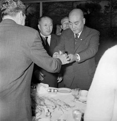 Adolfo López Mateos entregando un presente a un funcionarios Japones, durante un banquete