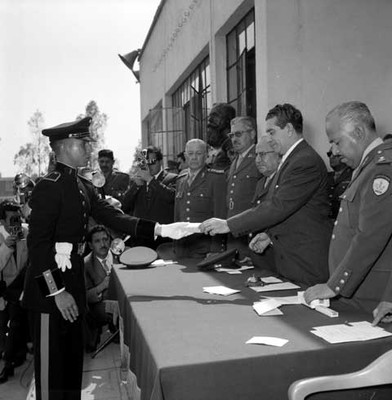 Adolfo López Mateos entrega presente a cadete durante la inauguración de cursos de la Escuela Médico Militar