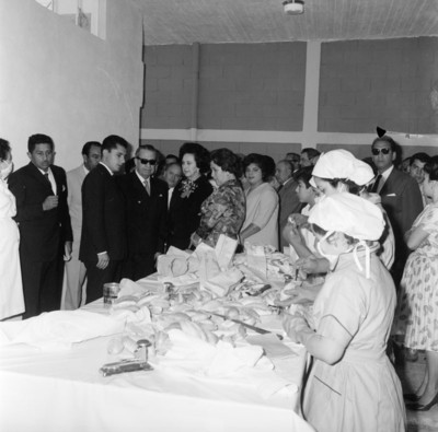 Eva Sámano, Herlinda Torres, Jaime Torres Bodet y funcionarios observando la elaboración de desayunos escolares en la planta de Cuernavaca