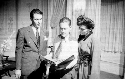 Actores con director observando un guión en la filmación de una película