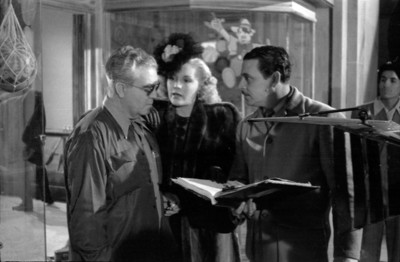 Director con pareja de actores leyendo libreto durante filmación de una película