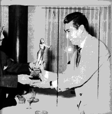 Pablo Beltrán Ruiz, músico compositor, recibiendo un trofeo de parte de otro hombre