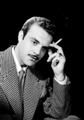 Eduardo Fajardo, actor, viste saco a cuadros, con cigarro en mano, retrato