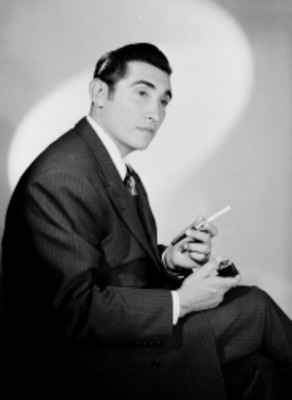 Rodolfo Acosta, actor, sentado con cigarro en mano, retrato
