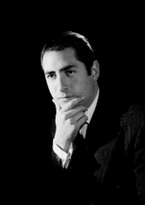 Luis Beristáin, actor, con la mano en su barbilla, viste de traje y corbata, retrato